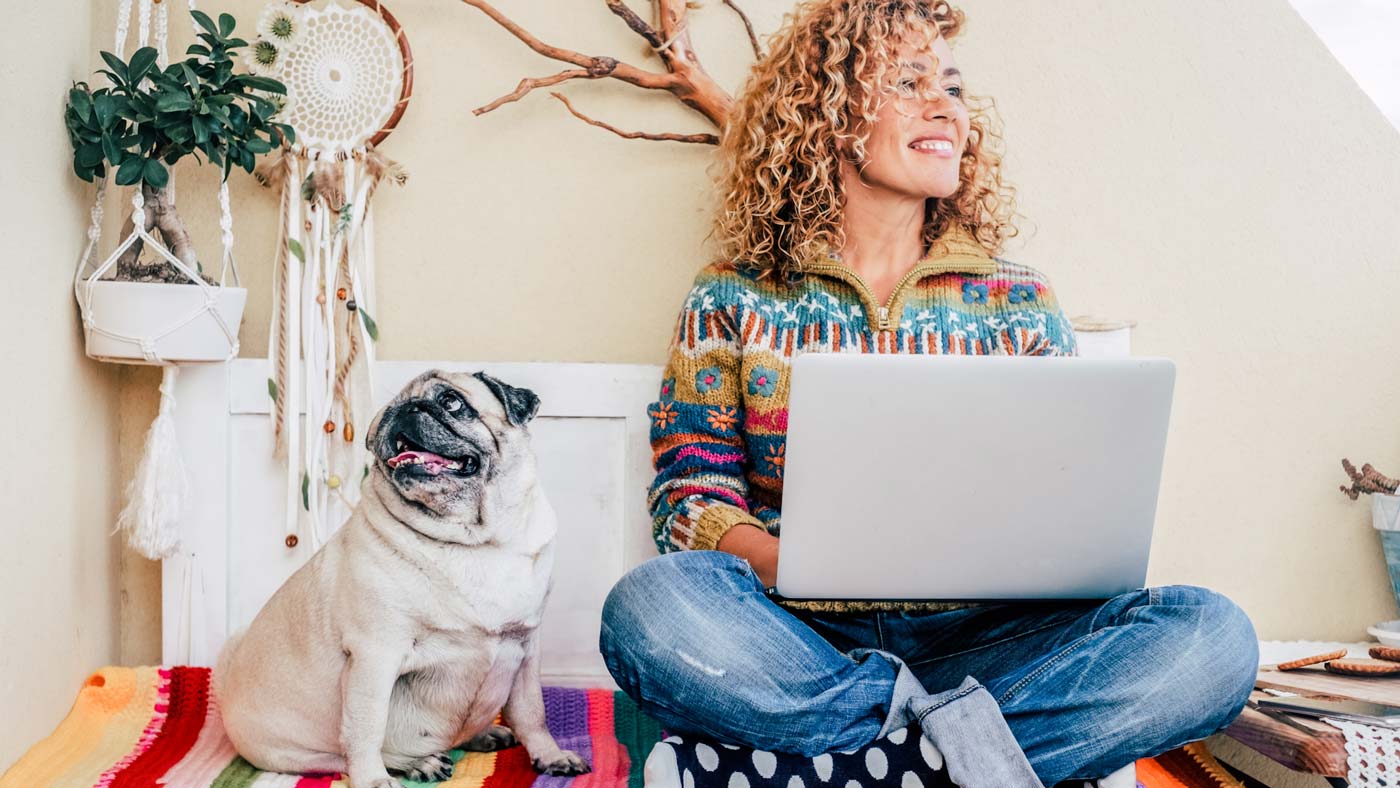 Woman on laptop sitting with her dog